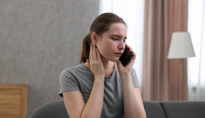 woman talking on phone looking stressed