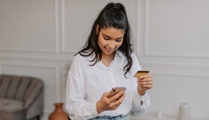 woman using her credit card on her phone