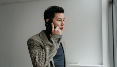 man on phone talking and looking worried