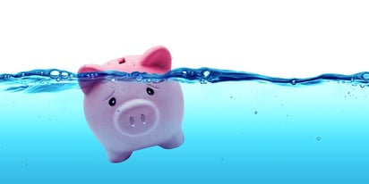 piggy bank in water drowning in debt concept