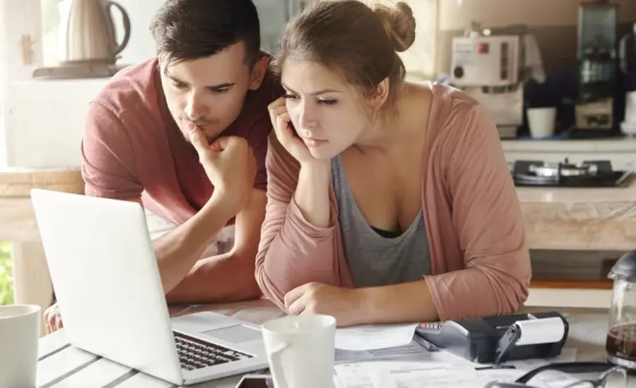 couple looking at the laptop and thinking