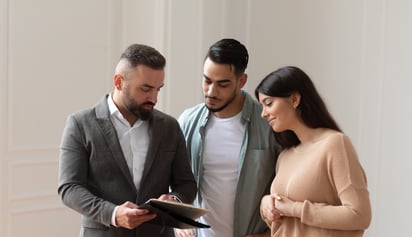 couple with a realtor looking at documents