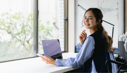 woman working on her laptop and smiling