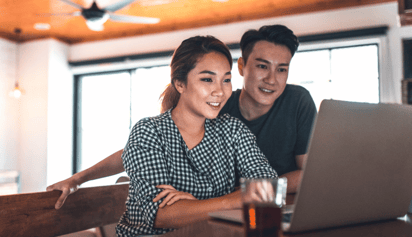 a man and a woman creating a budget on their laptop