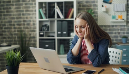 woman looking at her laptop worried