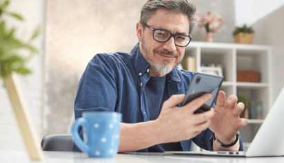 man wearing glasses checking his credit score on his phone