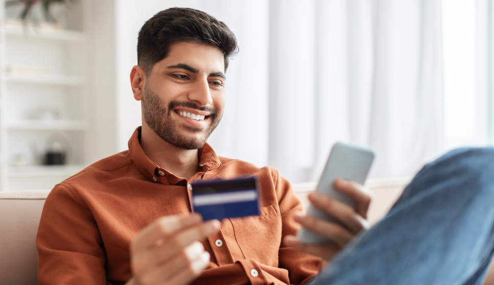 man holding a credit card and smiling