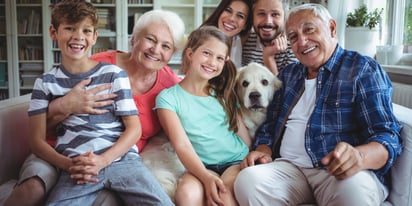 family sitting on a couch smiling.