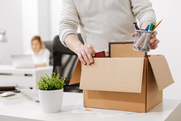 person packing a box due to layoff