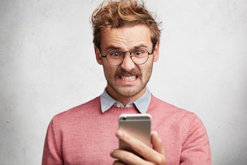 Angry man looking at phone