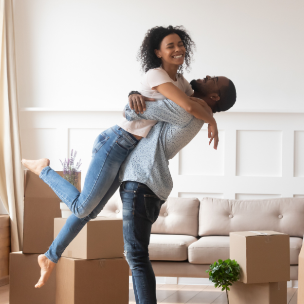 man holding a woman in his arms with boxes around them
