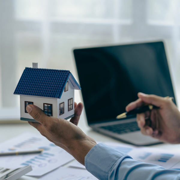 Hand holding a house and a pen