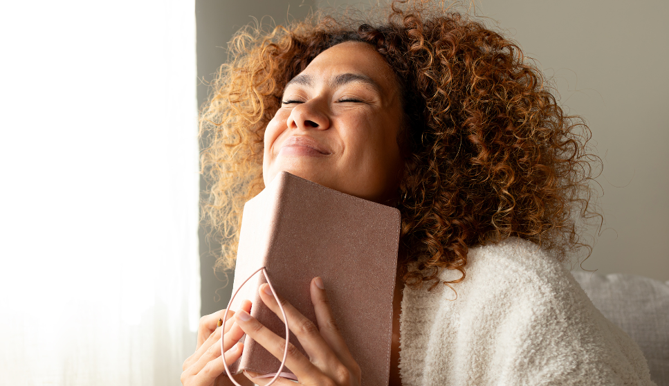 woman holding a book and smiling