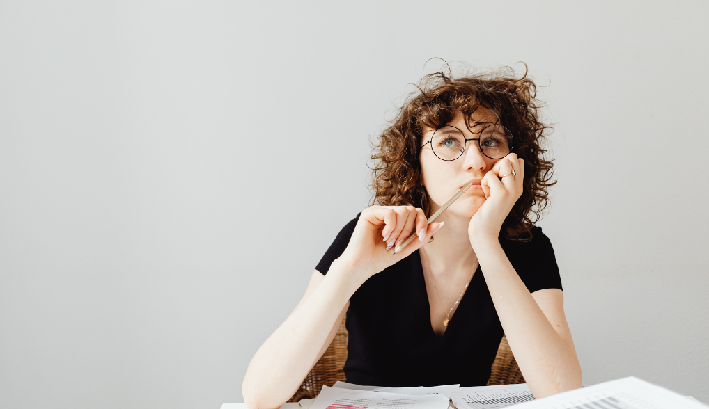 woman wearing glasses thinking